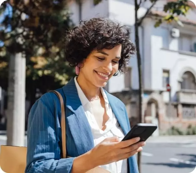 Woman smiling while looking at her phone